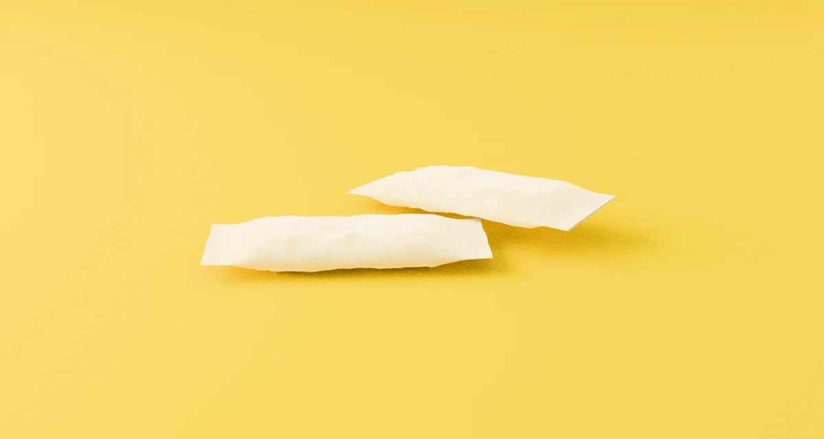 Two VOID pouches on yellow paper, close up: soft, slim and pillowed, with crimped ends.
